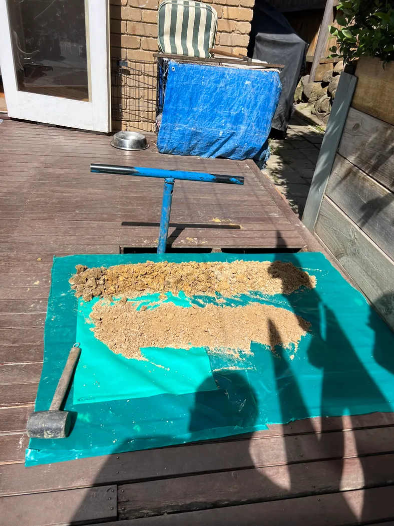 Hand auger and soil samples laid out beside a residential deck