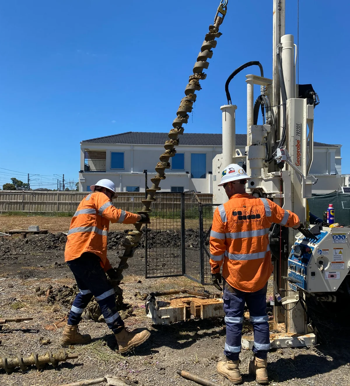 Drilling crew handling an auger beside a rig at the Lyndhurst investigation site.