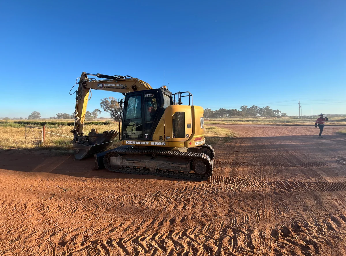 Tracked excavator on the red-earth surface at the Yanco BESS investigation site.